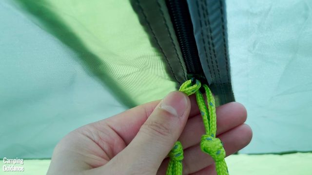 This is a picture of me holding the 2 zippers on 1 of the windows inside the Outdoor Products 10-Person Instant Cabin Tent.