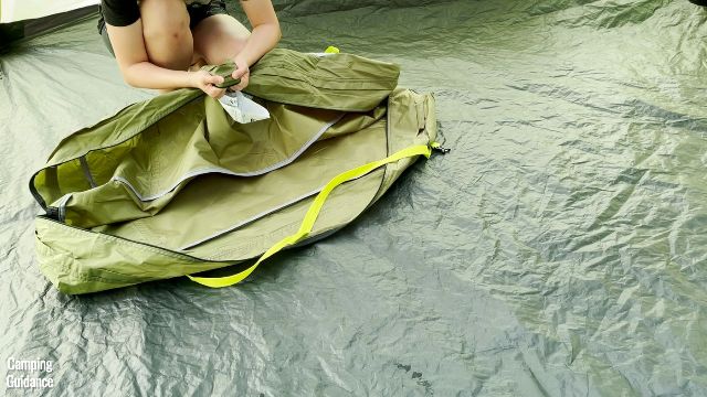 This is a picture of me pulling on the fabric of the carry bag of the Outdoor Products 10-Person Instant Cabin Tent.
