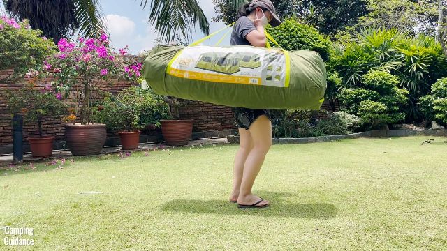 This is a picture of me carrying the Outdoor Products 10-Person Instant Cabin Tent by the shoulder straps of the carry bag.