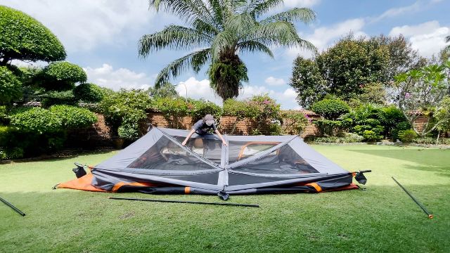 This is a picture of me struggling with the inverted roof of the Core 10-Person Straight Wall Cabin Tent.