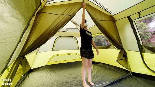 This is a picture of me stretching my arm out to touch the top of the Outdoor Products 10-Person Instant Cabin Tent (peak height of 77.5 inches).