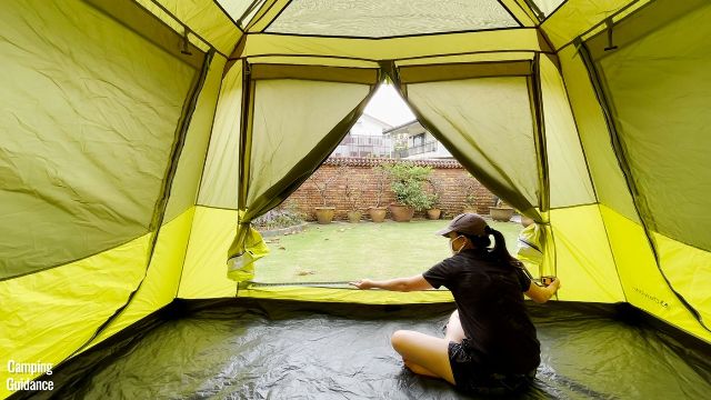 This is a picture of me using a tape measure to measure the length and width of the T-door of the Outdoor Products 10-Person Instant Cabin Tent (72 by 51 inches).