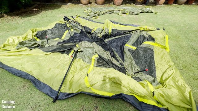 This is the tent body of the Outdoor Products 10-Person Instant Cabin Tent flat on the ground. Notice that the black center or middle hub is sticking out from the middle of the tent body.