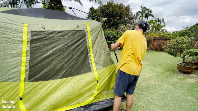 This is a picture of my brother extending one of the telescoping wall poles of the Outdoor Products 10-Person Instant Cabin Tent.