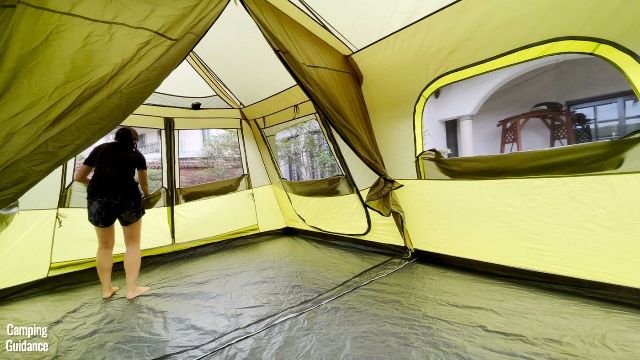 This is a picture of me unzipping all the mesh panels inside the Outdoor Products 10-Person Instant Cabin Tent. From left to right, we have the T-door, side-door, and a regular window.