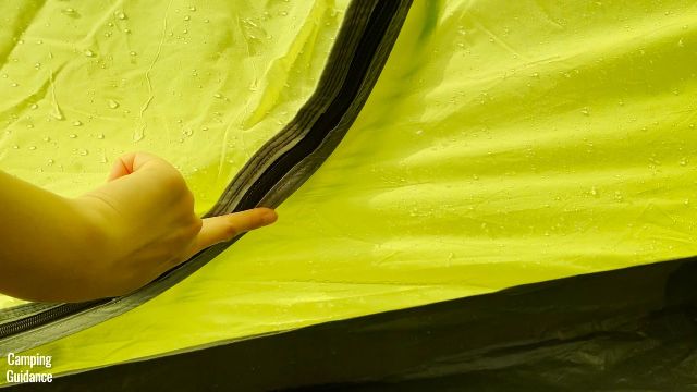 This is a picture of me touching one of the zips of the side doors in the Outdoor Products 10-Person Instant Cabin Tent, because it was leaking a little bit.