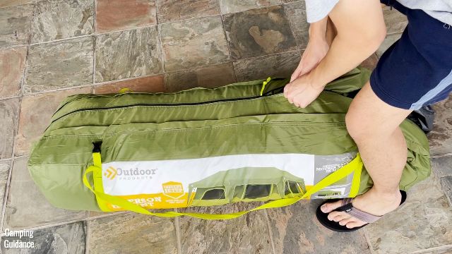 This is a picture of my brother zipping up the carry case of the Outdoor Products 10-Person Instant Cabin Tent.