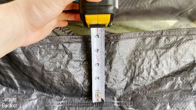 This is a picture of me using a tape measure to measure how high the bathtub feature of the Quechua 2 Seconds Fresh and Black Tent extends up to.
