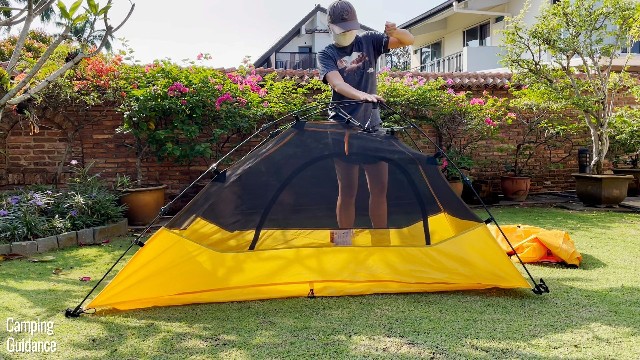 This is a picture of me using one hand to lift the drawstring at the very top of the Teton Sports 1-Person Vista Quick Tent, and using my other hand to push down on the hub to pop the tent up.