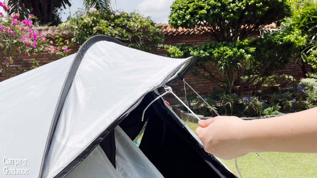 This is a picture of me attaching one of the provided guylines to one of the guyout points on the Quechua 2 Seconds Fresh and Black Tent.