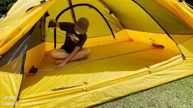 This is a picture of me using a tape measure to measure the base dimensions of the Teton Sports 2-Person Vista Quick Tent.