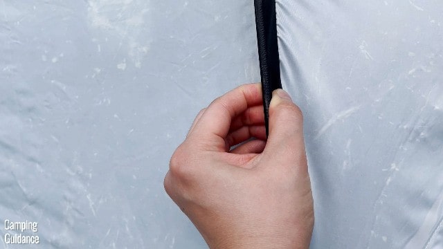 This is a picture of me gripping one of the fiberglass poles of the Quechua 2 Seconds Fresh and Black Tent. The pole is not visible at all in the picture, it is fully pre-attached to the black pole sleeve.