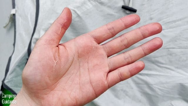 This picture shows that my hand is damp from touching the underside of the rainfly of the Coleman 2-Person Pop Up Tent after the 15-minute heavy rain test.