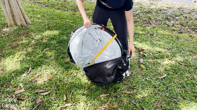 This is a picture of me taking the Quechua 2 Seconds Fresh and Black Tent out of the carry bag. Notice that there’s a yellow strap across the tent.