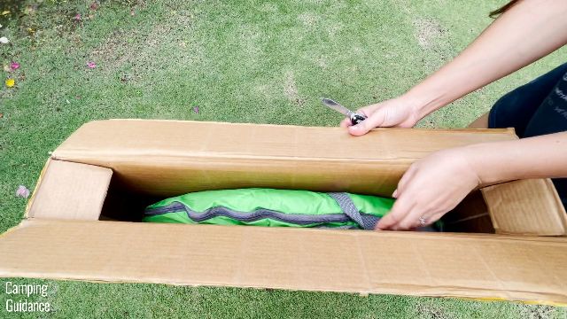This is a picture of me taking the Coleman 2-Person Pop Up Tent out from its cardboard packaging.