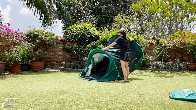 This is a picture of me unfolding the Quechua 2 Seconds Pop Up Tent, after undoing both the red and yelllow buckles.