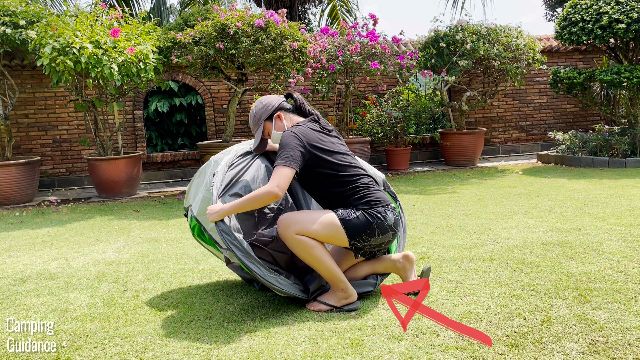 This is a picture of me using my knee to hold the Coleman 2-Person Pop Up Tent down while folding it away.