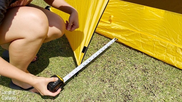 This is a picture of me using a tape measure to measure the width of each vestibule of the Teton Sports 2-Person Vista Quick Tent.