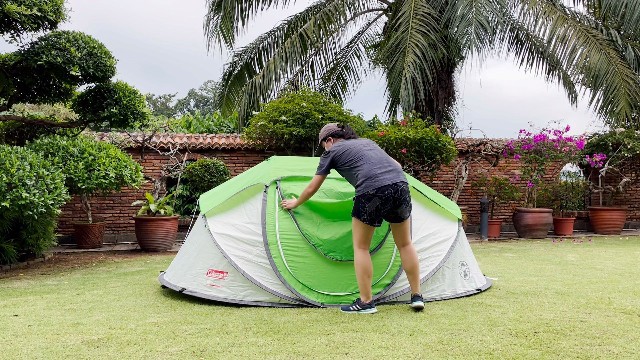 This is a picture of me unzipping the outer green door of the Coleman 4-Person Pop Up Tent.