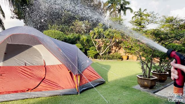This is a picture of me using a water hose to conduct a heavy rain test on the Coleman Red Canyon 8-Person Tent.