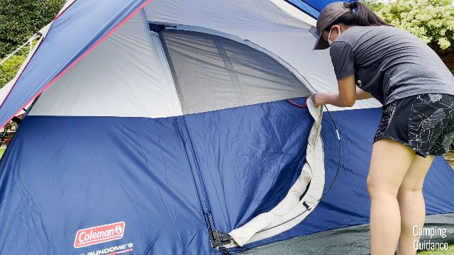 A picture of me zipping the hinged door pole up in the pole sleeve.