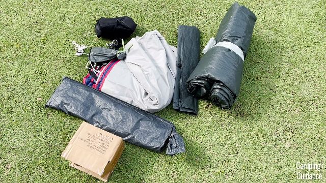 Here’s everything that came with the Coleman Elite Sundome Tent. From left to right: Cardboard box containing the lantern and power pack, poles in a carry case, rainfly (white), stakes in a carry case, small bag (black), foot mat, and tent body.