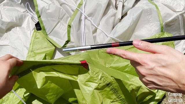 The rainfly fiberglass pole of the Coleman Montana 8-Person Tent is black with a red ring, and the pole sleeve in the rainfly is similarly color-coded red.