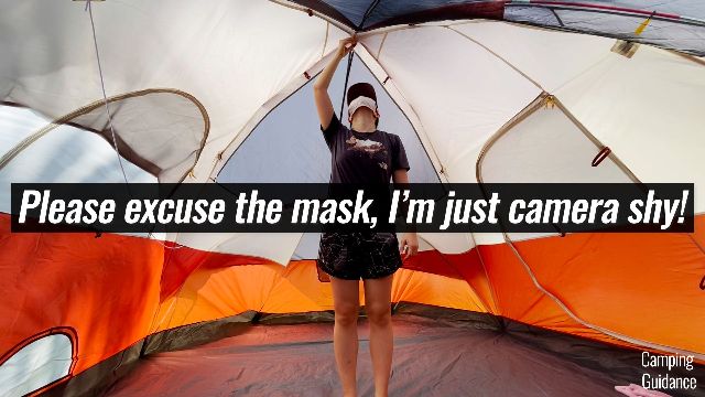 This is a picture of me standing under the peak height of the Coleman Red Canyon 8-Person Tent. I can easily reach the top of the tent by extending my arm up a little.