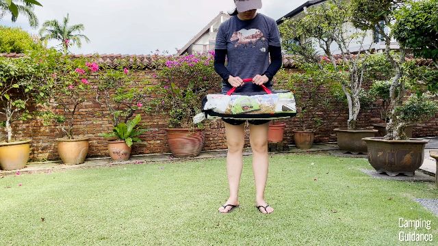 This is a picture of me carrying a packed-up Coleman 2-Person Sundome Tent.