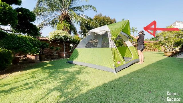 This is a picture of me securing the rainfly to the top of the Coleman Sundome 6-Person Tent.
