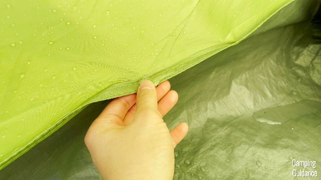 Notice the small puddles of water on the flooring of the Coleman Montana 8-Person Tent. The seam where my finger is was leaking water into the tent.