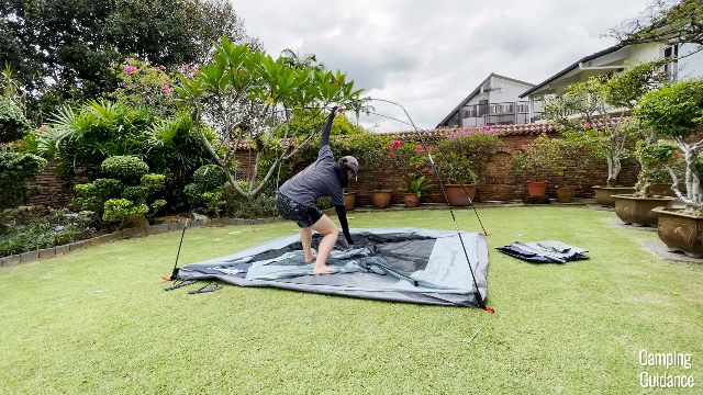 In this picture, I’m bending down to pick up the center pole clips to attach to the poles of the Coleman Skydome Tent.