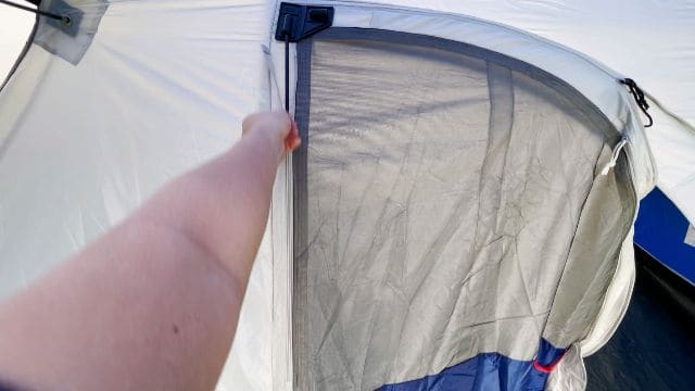 A picture of me zipping up the straight pole sleeve of the hinged door.