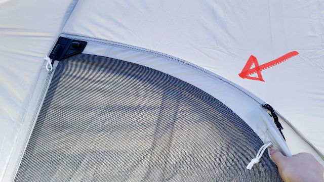 The red arrow is pointing to the pole sleeve for the curved part of the hinged door. My hand at the bottom right is right beside the zipper.