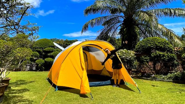 This is a picture of me standing in front of my REI Base Camp 6 in my yard.