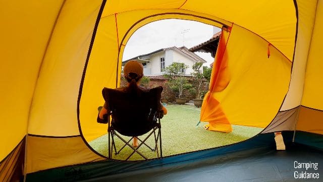 The author sitting on an REI camping chair in the front vestibule of the REI Base Camp 6.