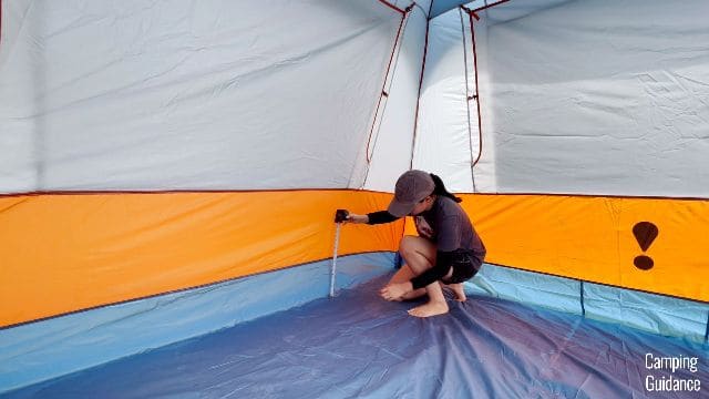 Me using a tape measure to measure the height of the bathtub flooring in the Eureka LX 6.