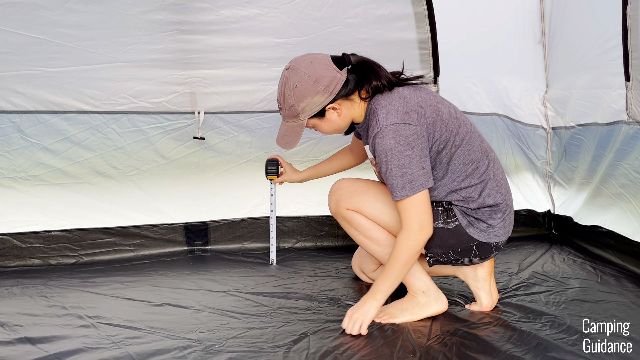 This is a picture of me using a tape measure to measure the height of the bathtub flooring in the Caddis Rapid 6.