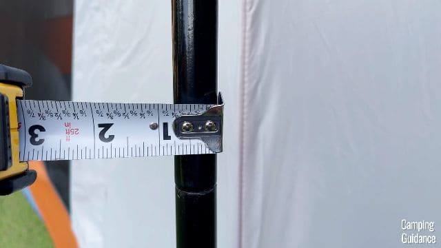 Using a tape measure to measure the width of the steel poles of the Eureka LX 6.
