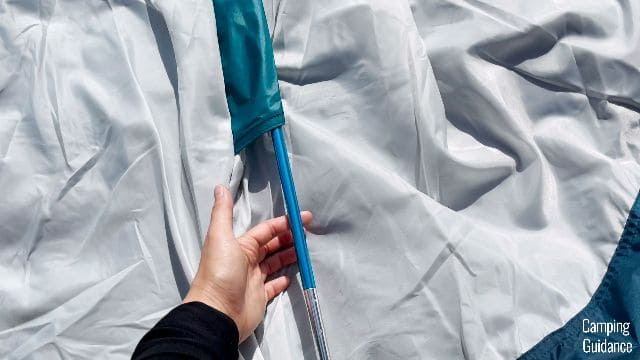 The blue pole goes into the blue pole sleeve of the REI Base Camp 6.