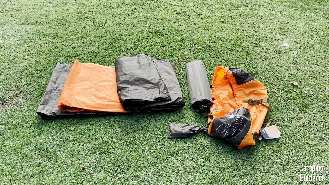 From left to right: tent body (black), rainfly (orange), stakes and guylines (smaller black carry bag), poles (bigger black carry bag), the overall carry bag (orange).