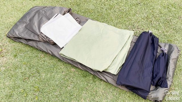 What the REI Wonderland 6 looked like when first unboxed. From left to right: tent body (brown), room divider (white), rainfly (light green), poles (bigger black carry bag), stakes and guylines (smaller black carry bag).