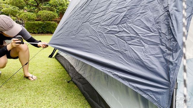 Me measuring how far I could guy out the rainfly for more ventilation through the windows.