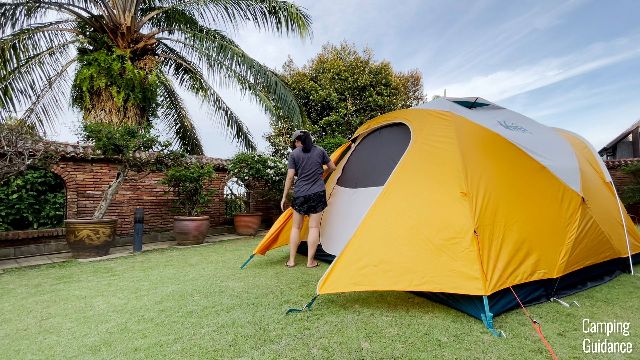 This is a picture of me unzipping the back vestibule door of the REI Base Camp 6.