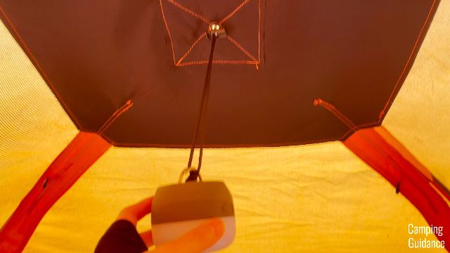 The author attaching a camp light to the top loop of the Gazelle T4 Hub Tent