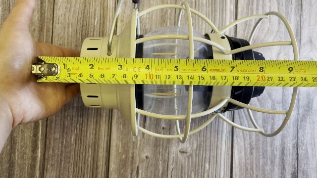 The author measuring the packed size of the Barebones Railroad lantern.