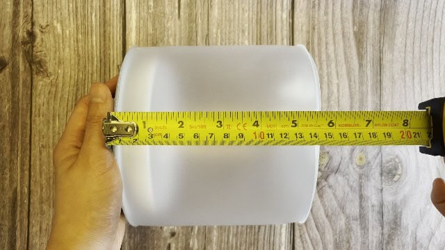 The author measuring the packed size of the BioLite Luci Charge 360 lantern.