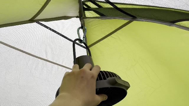 The Claymore Portable Fan V600+ hanging from the top of a tent with the aid of a carabiner.