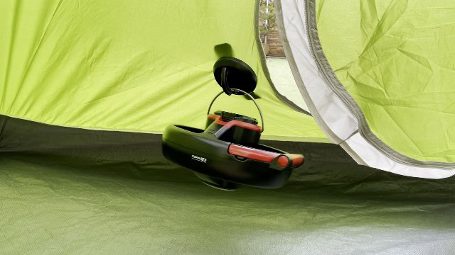 The Coleman CPX 6 Lighted Tent Fan hanging from its magnetic hook and plate.