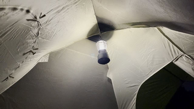 The Coleman Rugged Rechargeable 400 Lantern hanging at the top of a Coleman tent.